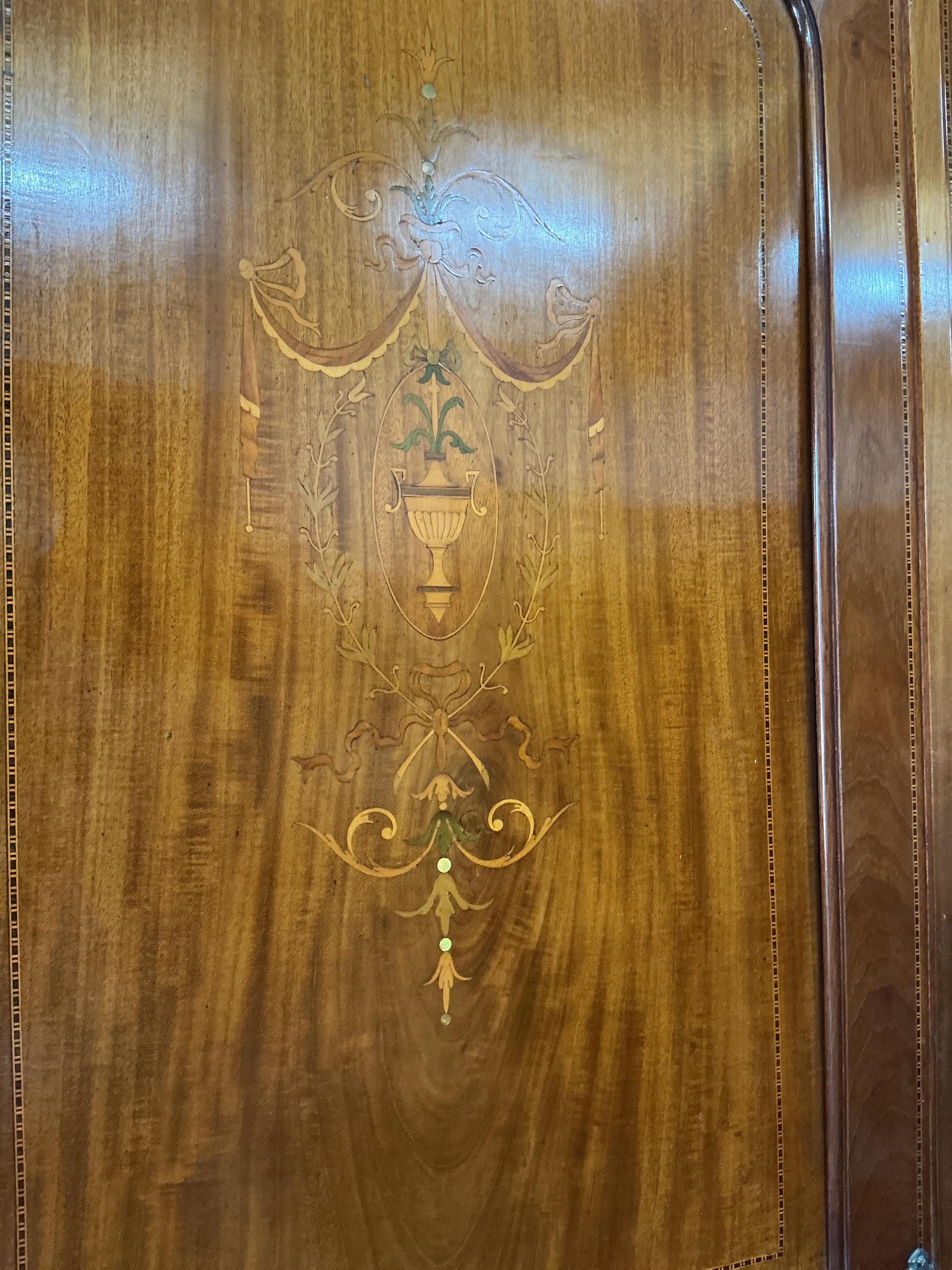 An Edwardian inlaid mahogany mirrored wardrobe, width 194cm, depth 61cm, height 214cm